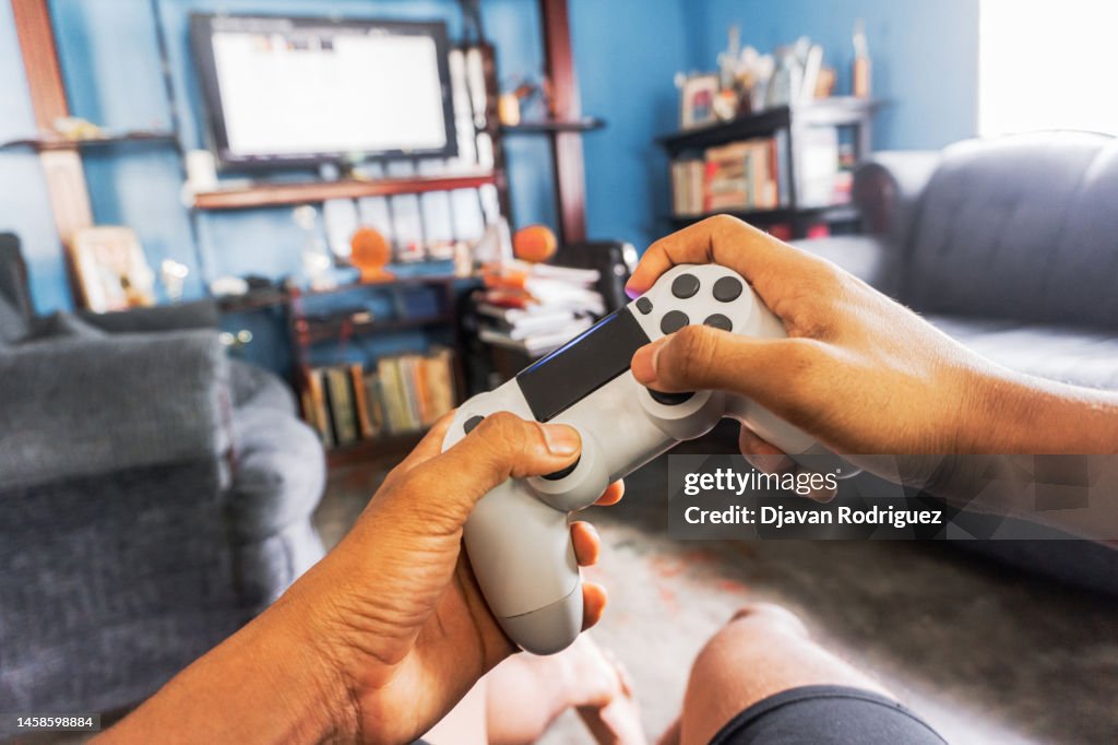 Hands holding a joystick play a game