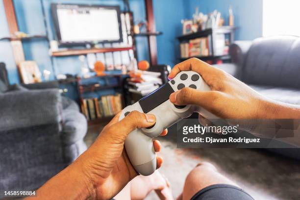 hands holding a joystick play a game - gaming imagens e fotografias de stock