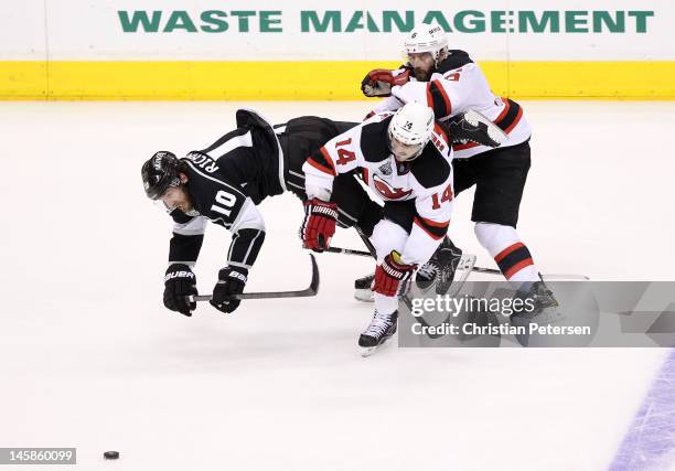 Mike Richards of the Los Angeles Kings skates for the puck over Adam Henrique and Andy Greene of the New Jersey Devils in Game Four of the 2012...