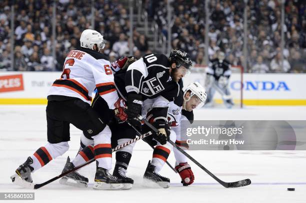 Mike Richards of the Los Angeles Kings skates for the puck over Adam Henrique and Andy Greene of the New Jersey Devils in Game Four of the 2012...