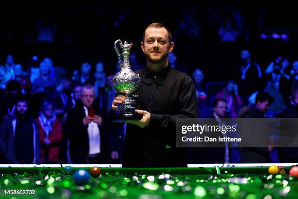 Mark Allen of Northern Ireland lifts the World Grand Prix trophy as he celebrates victory in the 2023 World Grand Prix final match against Judd Trump...