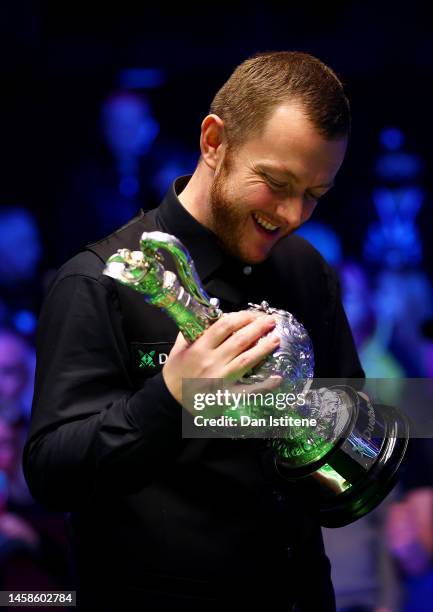 Mark Allen of Northern Ireland lifts the World Grand Prix trophy as he celebrates victory in the 2023 World Grand Prix final match against Judd Trump...