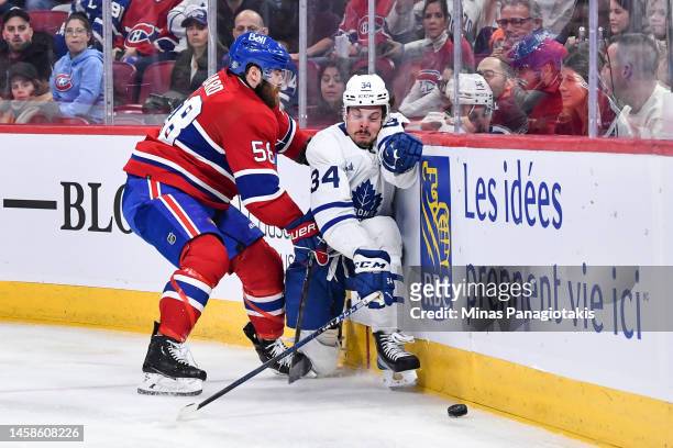 David Savard of the Montreal Canadiens pins Auston Matthews of the Toronto Maple Leafs against the boards during the third period at Centre Bell on...