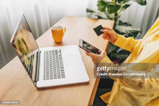 shot of pretty young woman shopping online with credit card and laptop while sitting on the floor at home. - credit score stock pictures, royalty-free photos & images