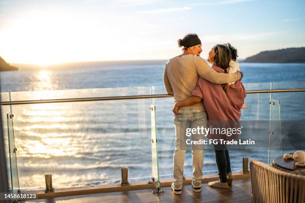 familie während des sonnenuntergangs bei kreuzfahrtreisen umarmt - kreuzfahrtschiff stock-fotos und bilder