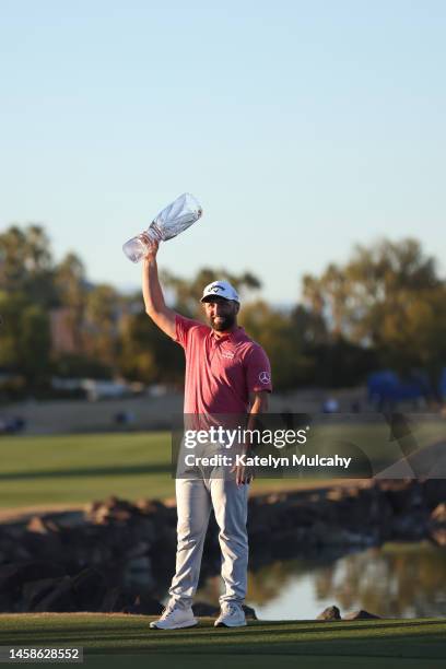 Jon Rahm of Spain celebrates with the trophy after winning during the final round of The American Express at PGA West Pete Dye Stadium Course on...