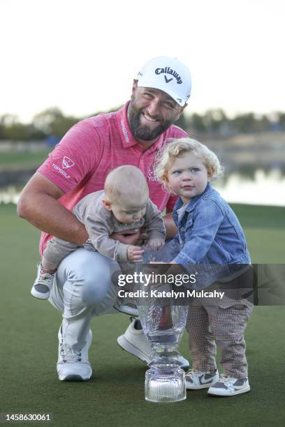 Jon Rahm of Spain celebrates with the trophy while holding his sons Kepa Cahill Rahm and Eneko Cahill Rahm after winning during the final round of...