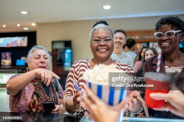 ladies buying snacks to watch the movie - the movie premiere stock pictures, royalty-free photos & images