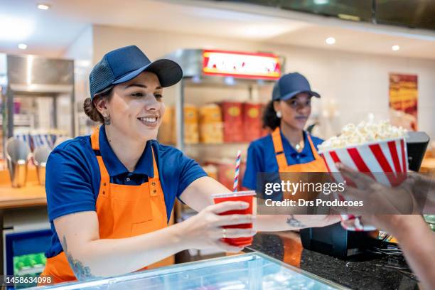 asistente entregando palomitas de maíz y refrescos - fast food fotografías e imágenes de stock