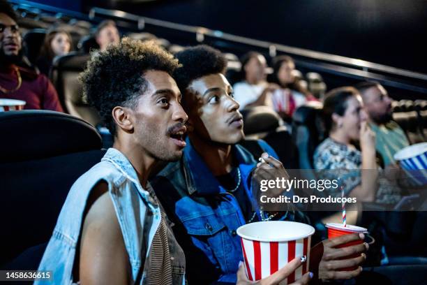 frightened gay couple watching the movie - freaky couples 個照片及圖片檔