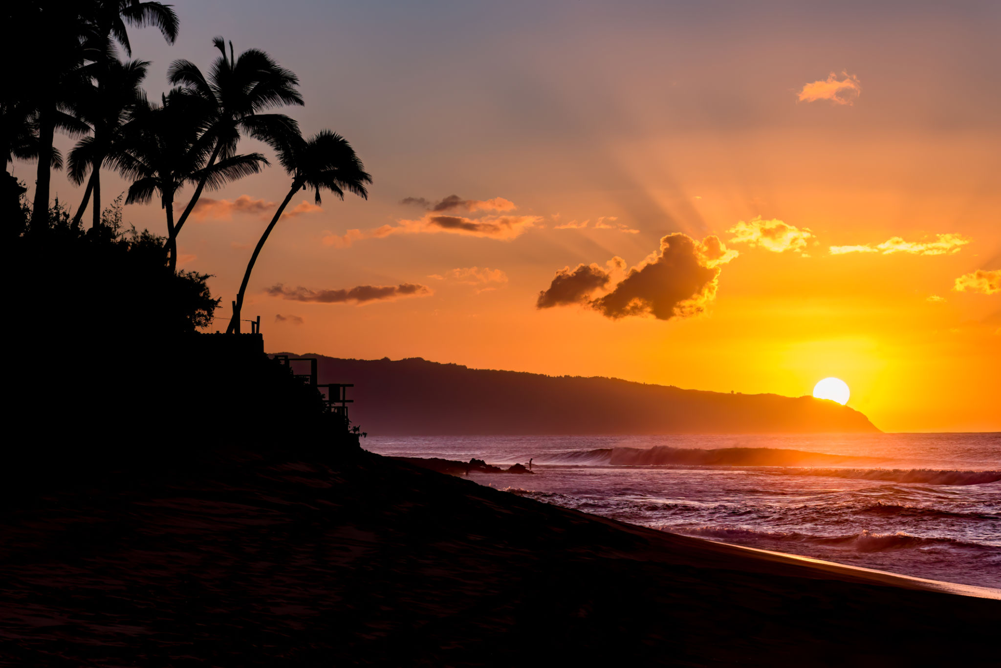 Sun setting over waves and palm trees on Sunset Beach, Hawaii Sun setting over waves and palm trees on Sunset Beach, Hawaii