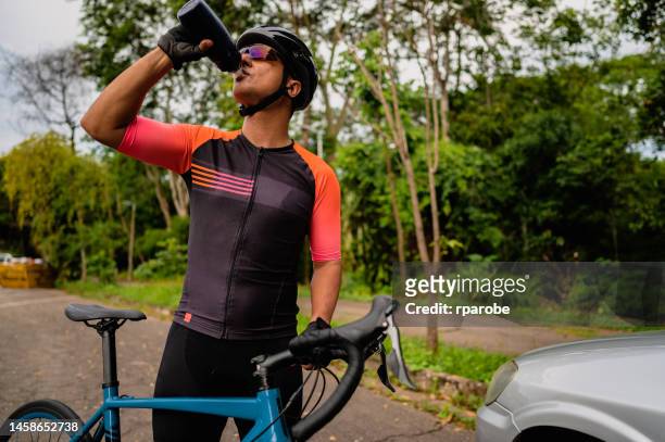 a cyclist man drinking water - men's cycling stock pictures, royalty-free photos & images