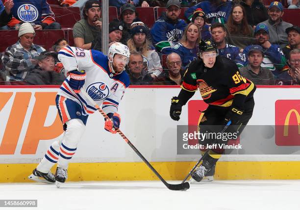 Leon Draisaitl of the Edmonton Oilers and Andrei Kuzmenko of the Vancouver Canucks skate up ice during their NHL game at Rogers Arena January 21,...