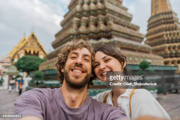 selfie eines mannes einer frau im wat pho tempel in bangkok - thai ethnicity stock-fotos und bilder