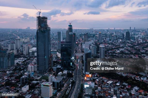 sunset over jakarta downtown in indonesia - 新興国 ストックフォトと画像