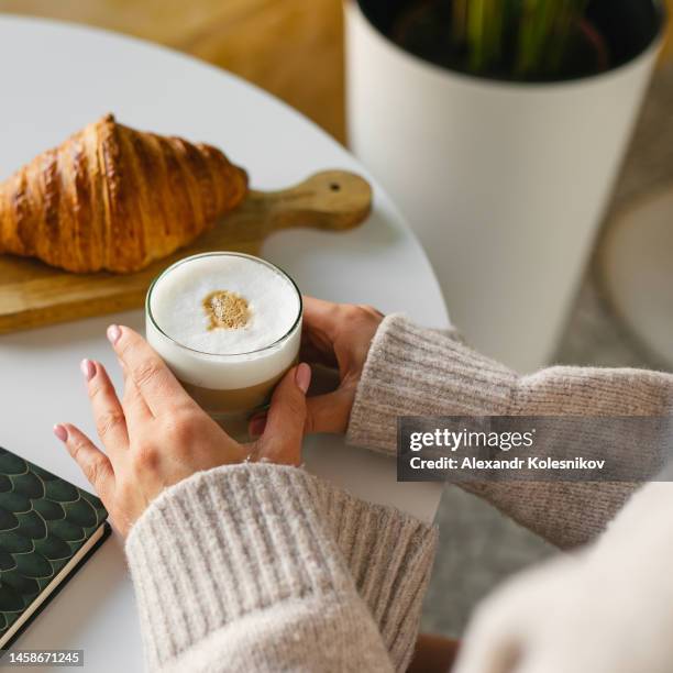 women holding cup of coffee on breakfast time with croissants. morning routine. - croissant café stock pictures, royalty-free photos & images