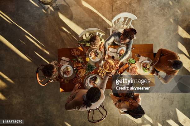 above view of black extended family having lunch at dining table. - family dinner table stockfoto's en -beelden