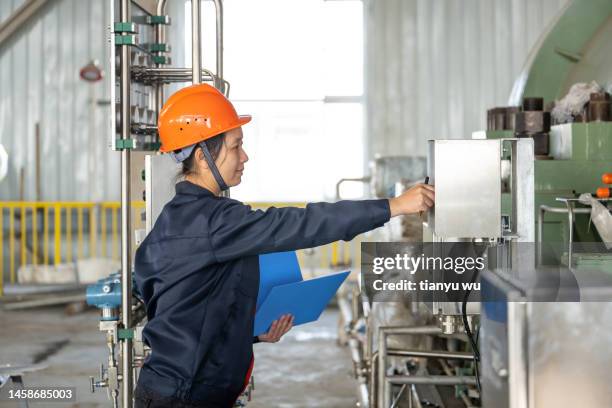 an asian female technician checks the equipment in the chemical plant - gas engineer stock pictures, royalty-free photos & images