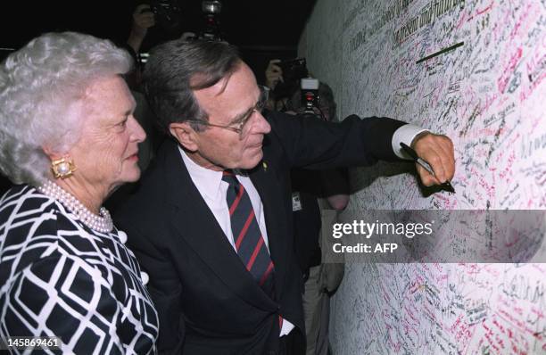 President George Bush signs the Earth pledge with his wife Barbara , 12 June 1992, during the UN-sponsored Earth summit in Rio de Janeiro.