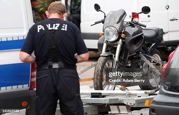 Police officer makes notes about a motorcycle that has been seized at the clubhouse of the motorcycle gang Bandidos Del Este on June 7, 2012 in...