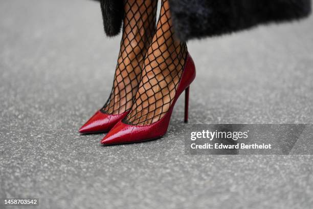 Emilie Joseph wears a black long fur belted coat from the Frankieshop, black fishnet / mesh tights, dark burgundy shiny leather pointed pumps heels...