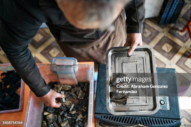 a jeweler taking jet stones out of a container and putting them in a tray - gemology stock-fotos und bilder