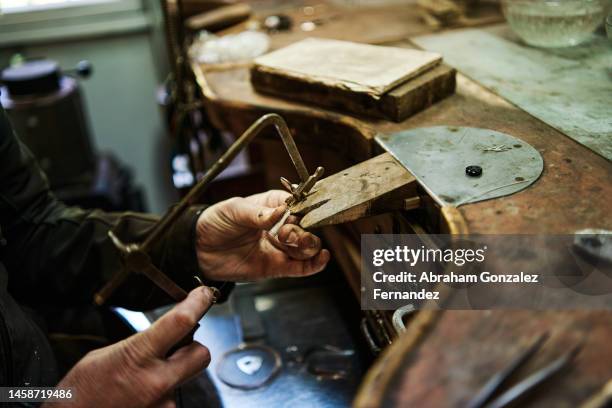 hands of unrecognizable adult man working with a saw in his jewelry workshop - jewelry making stock pictures, royalty-free photos & images