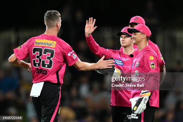 Jackson Bird, Steve Smith and Josh Phillipe of the Sixers celebrates the wicket of Ben McDermott of the Hurricanesduring the Men's Big Bash League...