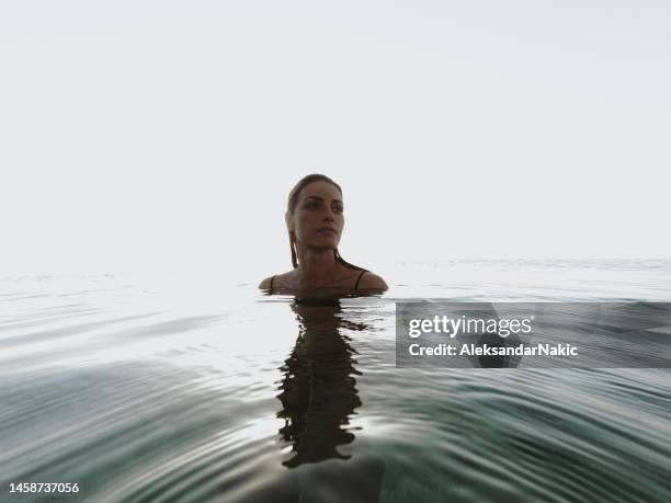 mujer joven nadando en el agua tranquila del mar - floating on water fotografías e imágenes de stock