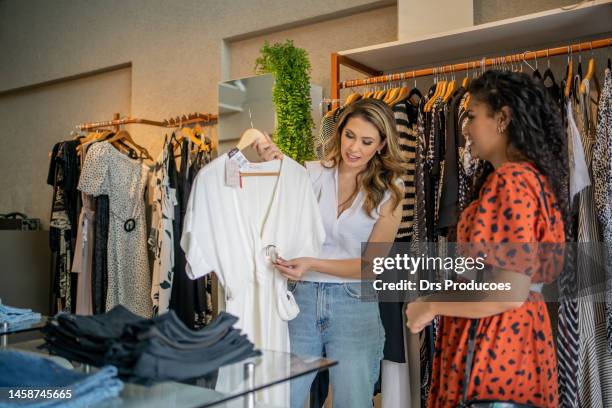 clothing saleswoman assisting a customer - saleswoman stock pictures, royalty-free photos & images