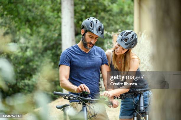 couple using e-bike in tuscany, italy: smartphone map - cycling helmet stock pictures, royalty-free photos & images