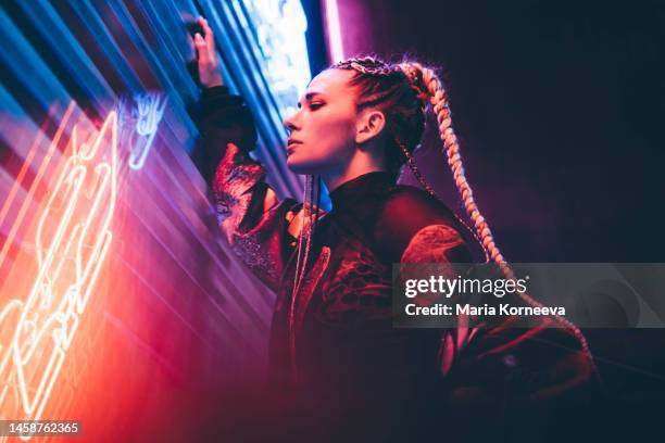 portrait of young woman illuminated neon light. - night of fashion for a cause to benefit stomp out bullying stockfoto's en -beelden