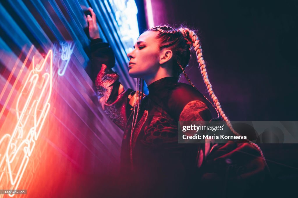 Portrait of young woman illuminated neon light.