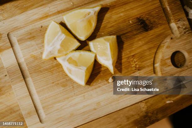 cutted lemon on a wooden cutting board - lisa bitter stock-fotos und bilder