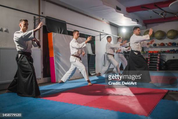 un maître d’aïkido s’entraîne avec un groupe de jeunes combattants - dojo photos et images de collection
