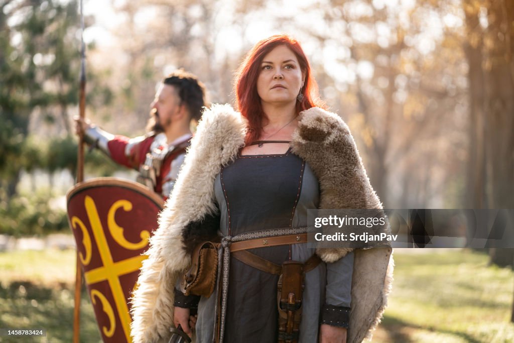 Selbstbewusste mittelalterliche Frau mit ihrem Ritter hinter sich