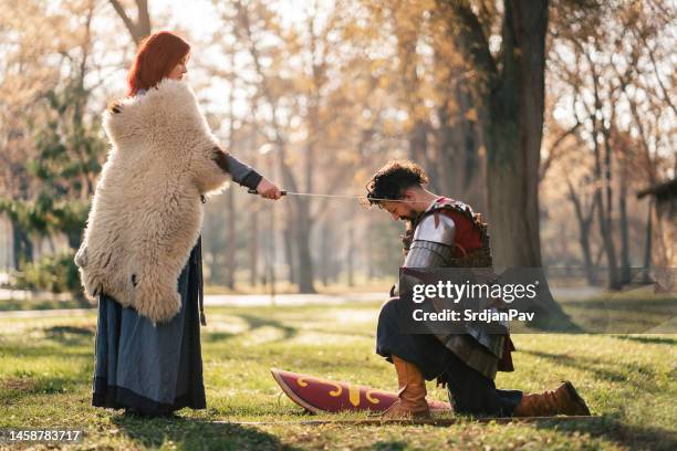 queen using sword for an initiation ceremony, while proclaiming the medieval warrior a knight - initiation ceremony stock pictures, royalty-free photos & images