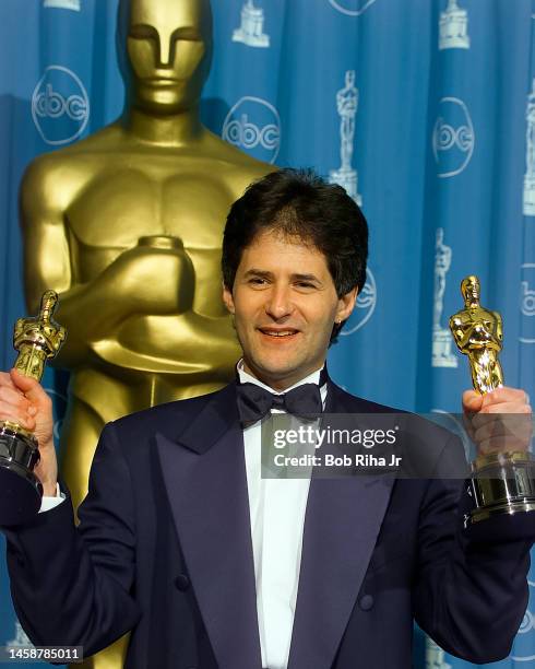 Winner Composer James Horner holds his two Oscars for Best Original Song and Best Dramatic Score for movie 'Titanic', backstage at the Academy Awards...