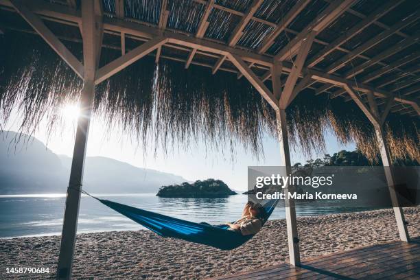 woman relaxing in hammock on beach - hammock stock pictures, royalty-free photos & images