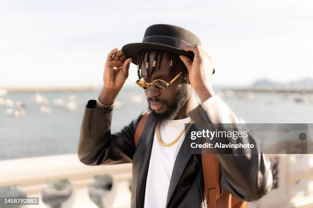 portrait of black man strolling by the sea - vestimenta informal ストックフォトと画像