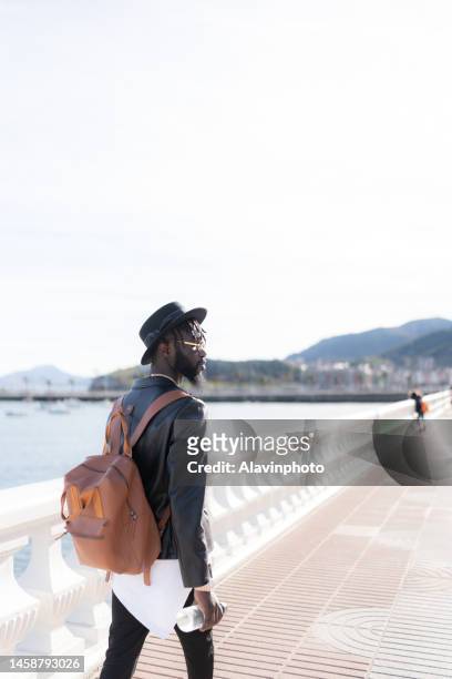 portrait of black man strolling by the sea - vestimenta informal ストックフォトと画像