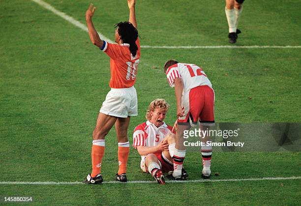 Ruud Gullit of Netherlands signals to the bench for treatment for Henrik Andersen of Denmark who is in agony as a knee injury strikes during the UEFA...