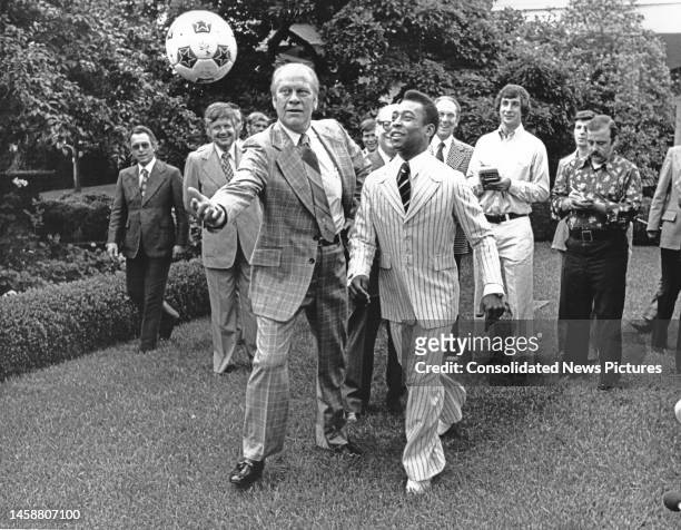 President Gerald Ford and Brazilian soccer player Pele play with a soccer ball in the White House's Rose Garden, Washington DC, June 28, 1975.