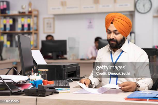 indischer sikh-geschäftsmann, der im büro arbeitet. archivfoto - sikhism stock-fotos und bilder