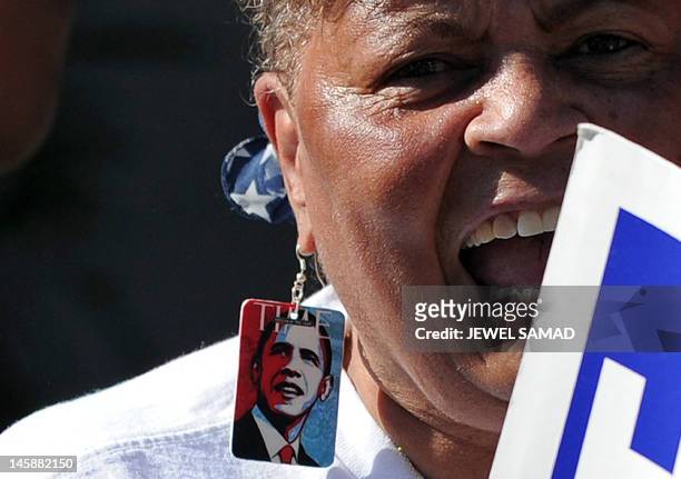 Supporter wearing earrings with US President Barack Obama's pictures on as she shouts slogans near a house where Obama is holding a campaign event in...
