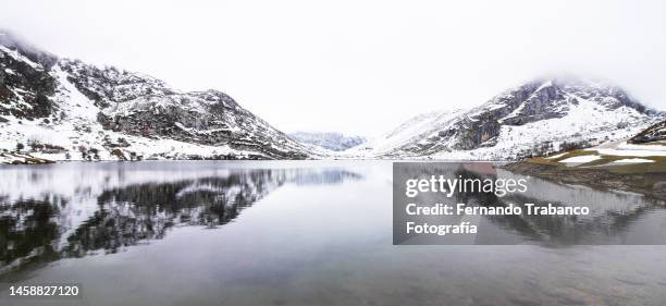 snowy mountains reflected in lake - covadonga stock pictures, royalty-free photos & images
