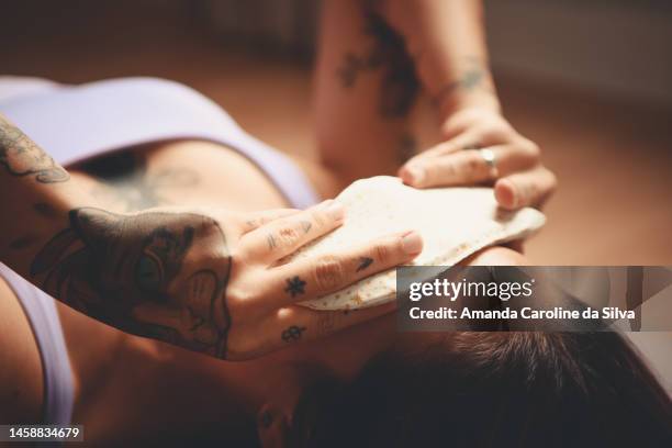 woman relaxing in savasana with a handmade eye patch - savasana stock pictures, royalty-free photos & images