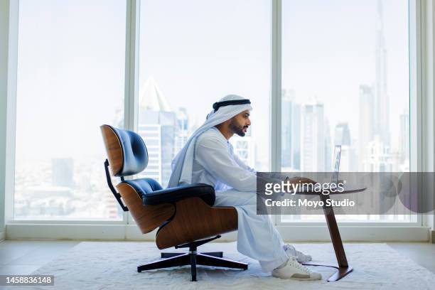 side view of bearded arab businessman working with laptop in modern office - emirati laptop stock pictures, royalty-free photos & images