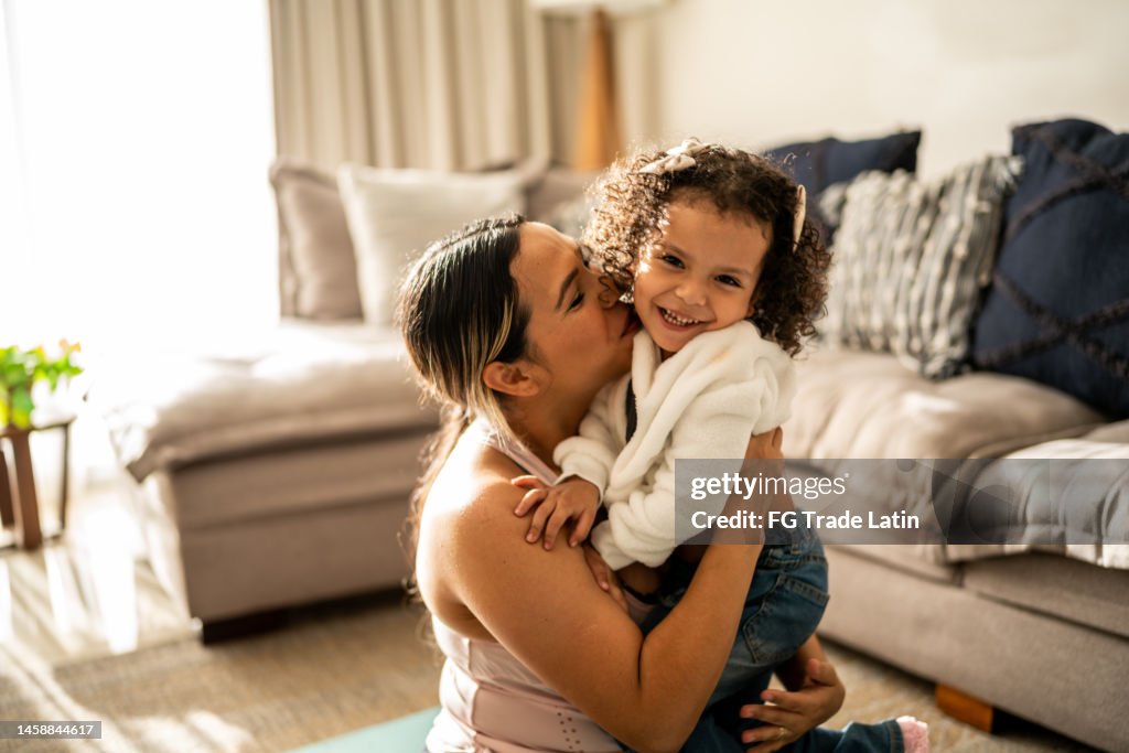 Portrait of toddler girl having fun with her mother in the living room at home