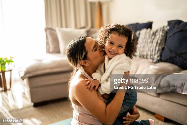 portrait of toddler girl having fun with her mother in the living room at home - mexican ethnicity stockfoto's en -beelden